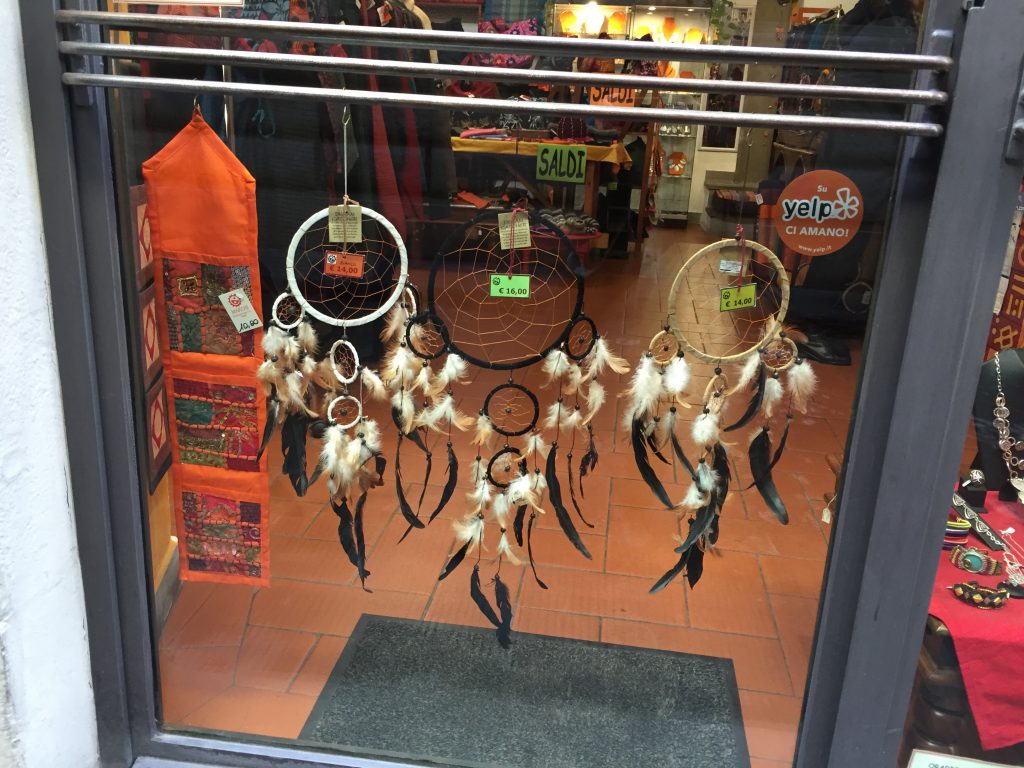 When religious icons get stripped of meaning. Dreamcatchers, with more dreamcatchers growing off the side, in an Italian tourist shop.